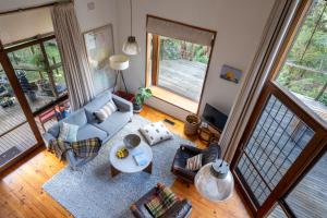 einen Blick über ein Wohnzimmer mit Sofa und Stühlen in der Unterkunft Dandenong Ranges Modernist Bush Escape in Kalorama