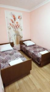 Cette chambre comprend deux lits et un tableau mural. dans l'établissement 2-х комнатная квартира, à Balkhach