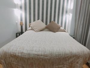 Una cama con dos almohadas encima. en AmoRoma Suite, en Roma