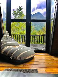 a pillow sitting on a wooden floor in front of a window at The Backyard Balangoda in Balangoda