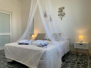 1 dormitorio con 1 cama blanca con dosel en DomoMea - C3 - IUN R5385 en Cagliari