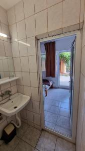 a bathroom with a sink and a door leading to a patio at Casa Mititelu in Costinesti
