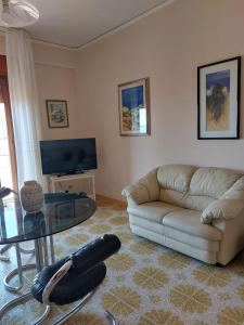 uma sala de estar com um sofá e uma mesa de vidro em Una Rosa Blu em Valderice