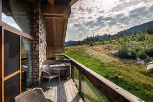 a balcony of a cabin with a view of a field at Mountica Jasná in Belá