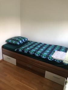 uma cama num quarto com uma estrutura de cama em Prenočišča Kovač em Beltinci