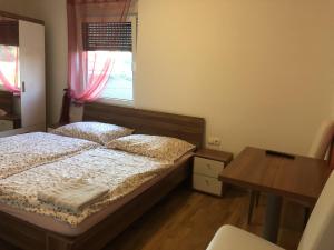 - une chambre avec 2 lits, une table et une fenêtre dans l'établissement Prenočišča Kovač, à Beltinci