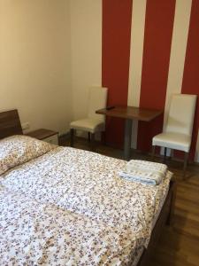 um quarto com uma cama, 2 cadeiras e uma mesa em Prenočišča Kovač em Beltinci