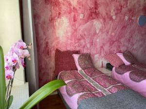 1 dormitorio con 2 camas y pared de color rosa en IloNam Asunto Kuopion ytimessä, en Kuopio