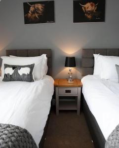 ダンヴェガンにあるAtholl House Skyeのベッドルーム1室(ベッド2台、ランプ付きのナイトスタンド付)