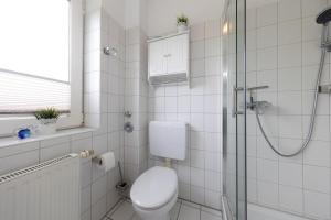 a white bathroom with a toilet and a shower at LM1-28 - Ferienwohnung Typ B Komfort in Schottwarden