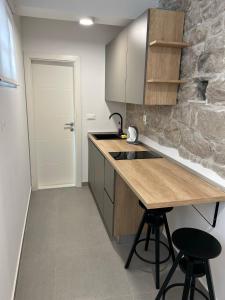 eine Küche mit einer Holztheke und einer Steinmauer in der Unterkunft Radunica old town - Studio apartment 1 in Split