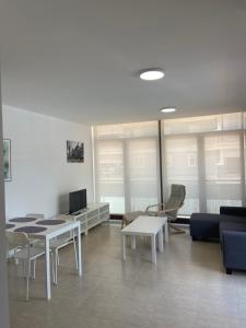 uma sala de estar com mesas e cadeiras e um sofá em Mirador dels Terrers em Benicàssim