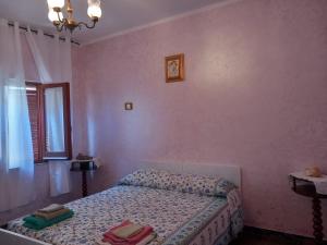 een slaapkamer met een bed en een roze muur bij casa Aurelia Ulassai 6 posti letto in Ulassai