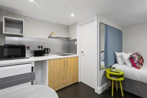 a small apartment with a kitchen and a bed at Unique single occupancy studio in London