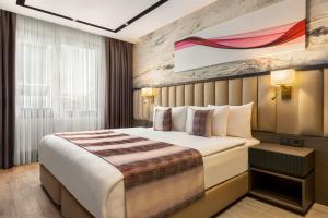 a hotel room with a bed and a painting on the wall at Ramada by Wyndham Istanbul Umraniye in Istanbul
