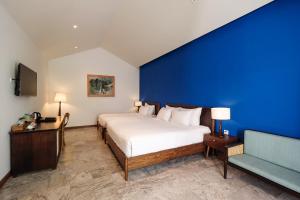 a bedroom with a large bed and a blue wall at Salmalia Boutique Hotel & Spa in Da Nang +115 photos