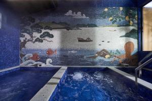 a swimming pool with a mural on the wall at Azumi Setoda in Onomichi