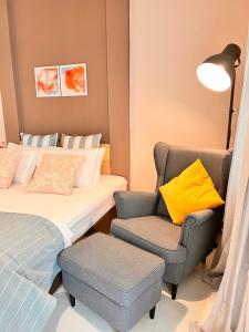 a bedroom with a bed and a chair and a lamp at Por poshtel Kanchanaburi in Kanchanaburi City