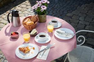 ein rosa-weißer Tisch mit Speisen und Getränken in der Unterkunft Hotel Der Grischäfer in Bad Emstal