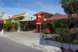 a street with houses and a car parked in front at OYO 1636 Wisma Kuta Karang in Lhokseumawe