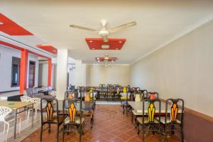 a dining room with chairs and tables and a ceiling fan at OYO 1636 Wisma Kuta Karang in Lhokseumawe