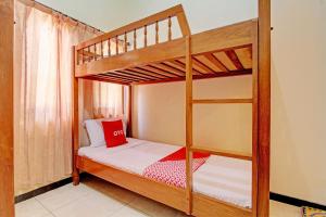 sypialnia z 2 łóżkami piętrowymi i czerwoną poduszką w obiekcie OYO 92912 Mtc Bunk Bed w mieście Salatiga
