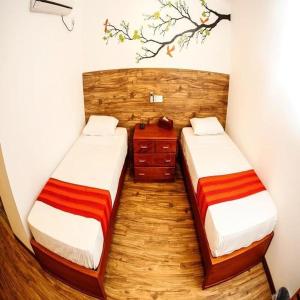 a room with two beds and a wooden floor at CityRest Fort in Colombo