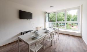 een eetkamer met een tafel en stoelen en een groot raam bij Stay & Work - 6 single beds - central in Emmerich
