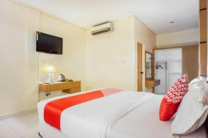 a bedroom with a large white bed with red pillows at OYO 1636 Wisma Kuta Karang in Lhokseumawe