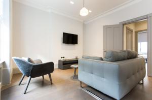 a living room with a couch and a chair at Soho Luxury 1 Bedroom Apartment by Concept Apartments in London