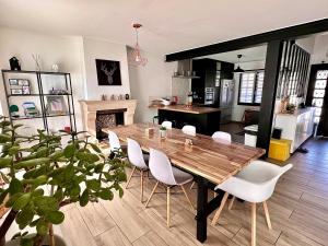 a dining room with a wooden table and white chairs at Family Oasis with 3 bedrooms near Paris in Chennevières-sur-Marne
