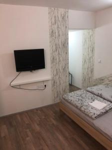 een slaapkamer met een bed en een flatscreen-tv aan de muur bij Apartment Ida in Piran