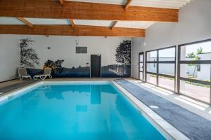 - une piscine d'eau bleue dans une maison dans l'établissement Logis Auberge De La Foret, à Le Gâvre