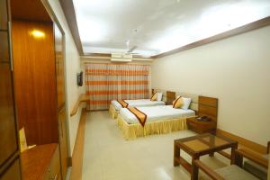 a hotel room with two beds and a table at Hotel Garden Inn in Sylhet