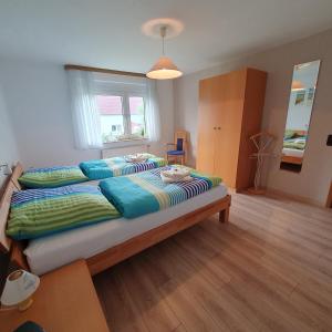a bedroom with a large bed with green and blue pillows at Fewo Tina und Günni in Aerzen