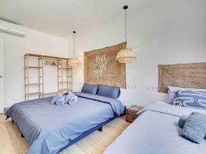 2 camas en un dormitorio con sábanas azules en Casa Mandarina: 4 Bedrooms - 2 Terraces - Parking, en Hospitalet de Llobregat