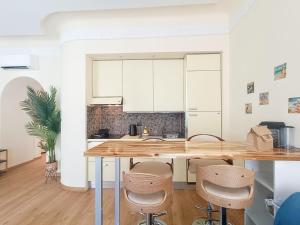 a kitchen with a wooden counter top and stools at France 66 4 Pers AC WiFi in Nice