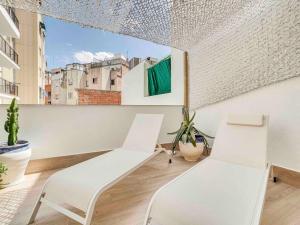 two white chairs in a room with a window at Casa Mandarina: 4 Bedrooms - 2 Terraces - Parking in Hospitalet de Llobregat