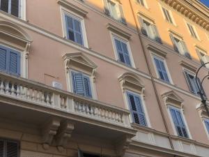 a building with blue windows and a balcony at Suite Inn Rome in Rome