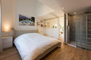 - une chambre avec un grand lit blanc et une douche dans l'établissement Duplex Cannes plein Centre, Zone Piétonne, 2 Chambres, à Cannes