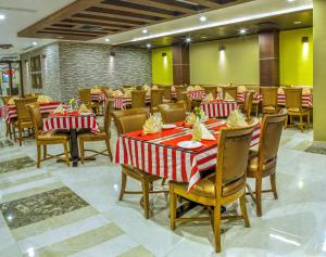 a restaurant with red and white tables and chairs at Chirag Inn in Trivandrum +15 photos