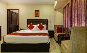 a hotel room with a bed and a chair at Chirag Inn in Trivandrum