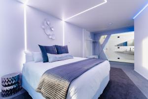 a bedroom with a large white bed with blue pillows at Errick's Boutique Accommodation in Dunedin