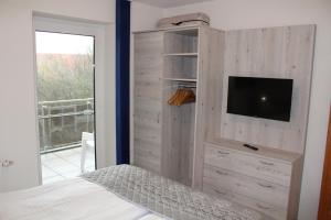 a bedroom with a tv on a wooden wall at LM5-11 - Ferienwohnung Typ B Komfort in Schottwarden