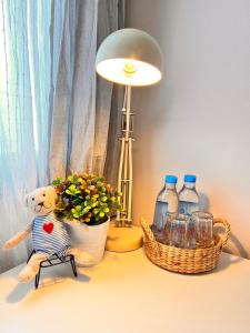 a stuffed bear sitting on a table next to a lamp at Por poshtel Kanchanaburi in Kanchanaburi City +79 photos