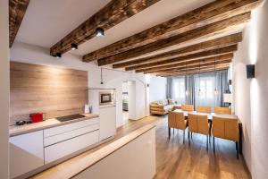 una cocina con armarios blancos y techos de madera. en Odilia - Historic City Apartments - center of Brixen, WLAN and Brixencard included, en Bresanona