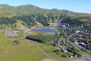 an aerial view of a town and a lake at Proches des pistes F2 36m2 4-6 pers 2 étoiles in Besse-et-Saint-Anastaise