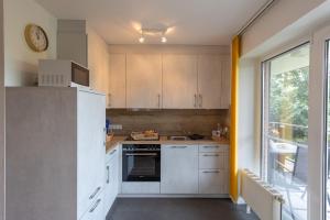 a kitchen with white appliances and a large window at LM5-11 - Ferienwohnung Typ B Komfort in Schottwarden