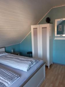 a bedroom with a bed with a blue wall at FeWo-Seestrasse in Diemelsee +19 photos