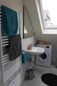 a bathroom with a sink and a washing machine at FeWo-Seestrasse in Diemelsee